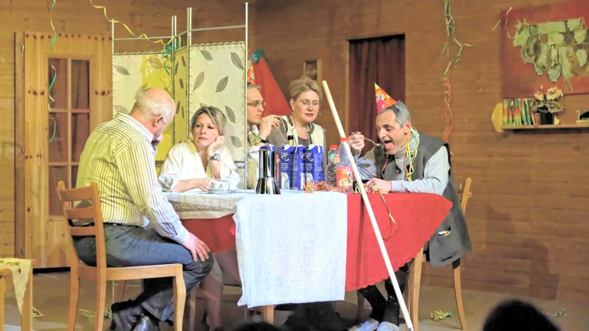 Deux familles mangent à la même table séparée par un pare à vent